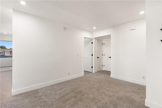 carpeted spare room featuring baseboards and recessed lighting