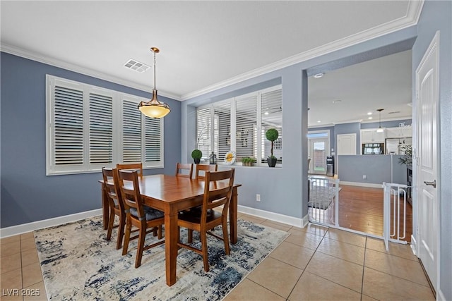 dining room with ornamental molding, visible vents, baseboards, and light tile patterned flooring