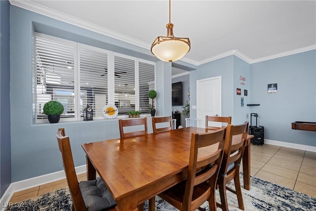 dining space featuring light tile patterned floors, ornamental molding, and baseboards