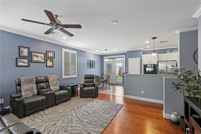 living room featuring ceiling fan, recessed lighting, baseboards, wood-type flooring, and crown molding