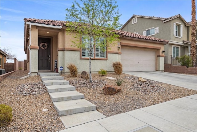 mediterranean / spanish-style house featuring concrete driveway, a tile roof, an attached garage, fence, and stucco siding