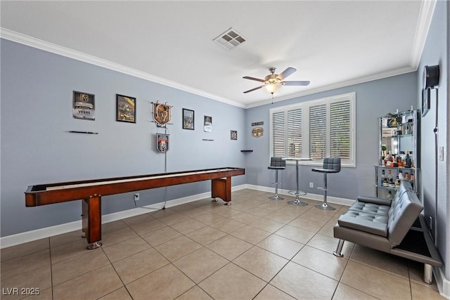 game room with crown molding, visible vents, a ceiling fan, light tile patterned flooring, and baseboards