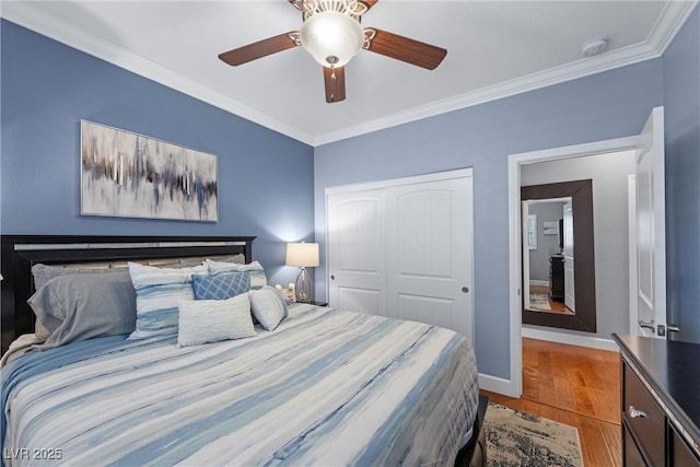 bedroom with baseboards, a ceiling fan, ornamental molding, wood finished floors, and a closet