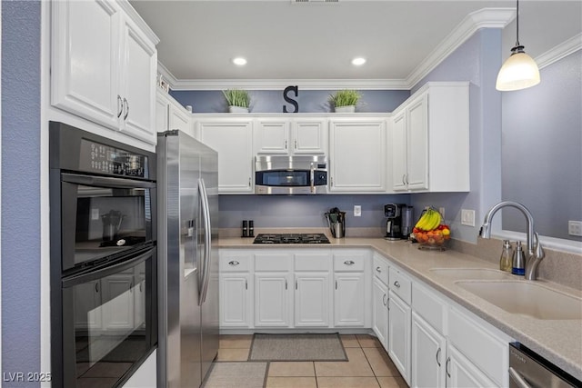 kitchen with crown molding, light tile patterned floors, appliances with stainless steel finishes, white cabinetry, and a sink