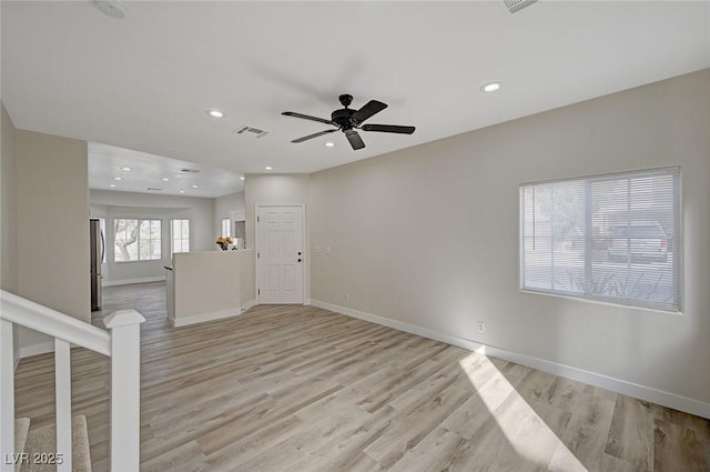 spare room with baseboards, visible vents, and light wood-style floors