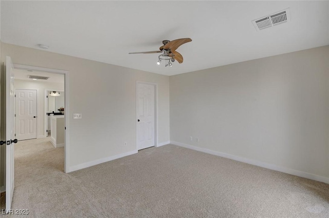 unfurnished bedroom featuring baseboards, visible vents, ceiling fan, and light colored carpet