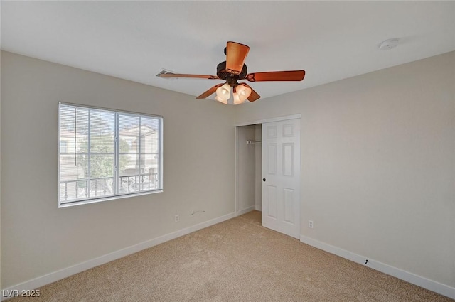 unfurnished bedroom featuring baseboards, a closet, a ceiling fan, and light colored carpet