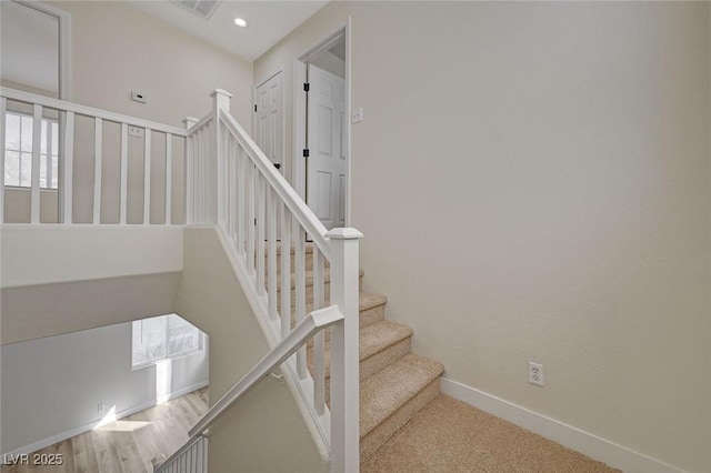 stairway with recessed lighting, visible vents, baseboards, and wood finished floors