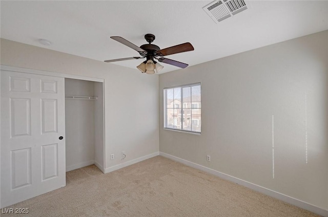 unfurnished bedroom with a closet, visible vents, light carpet, ceiling fan, and baseboards