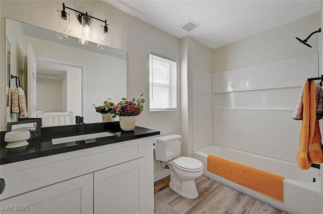 bathroom featuring shower / bath combination, visible vents, toilet, vanity, and wood finished floors