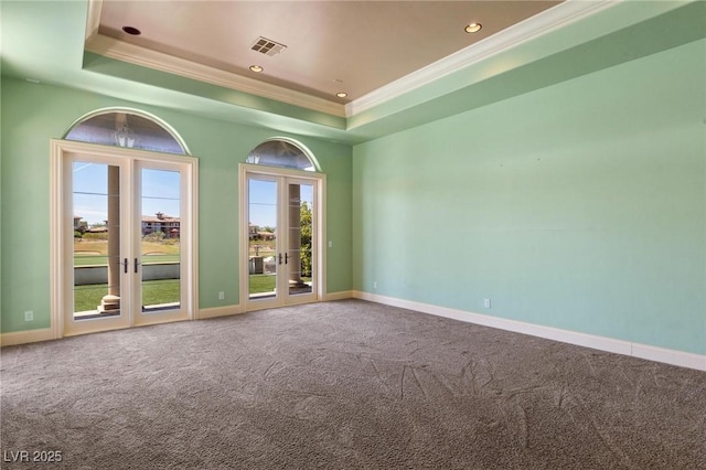 carpeted spare room featuring baseboards, visible vents, a tray ceiling, and french doors