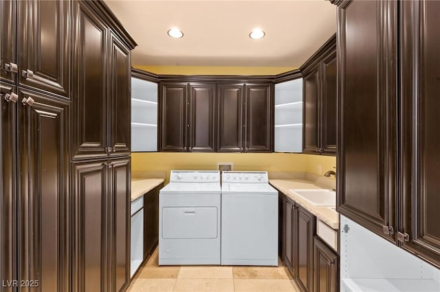 laundry area featuring light tile patterned floors, recessed lighting, cabinet space, a sink, and independent washer and dryer