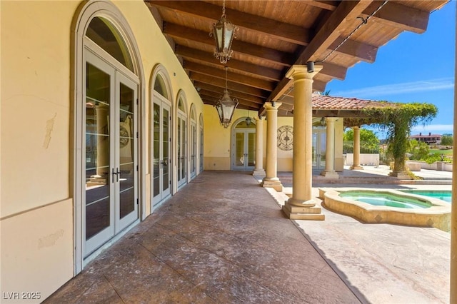 view of patio featuring an in ground hot tub and french doors