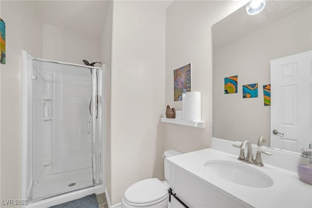 bathroom featuring a shower stall, toilet, and vanity