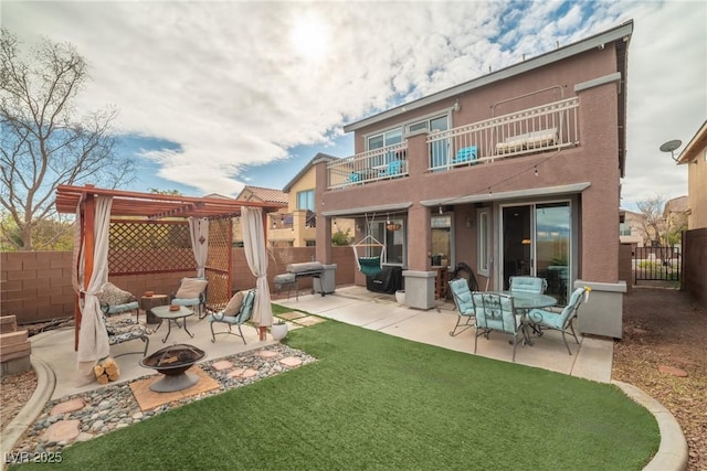 back of property featuring an outdoor fire pit, a balcony, a fenced backyard, a patio area, and a pergola