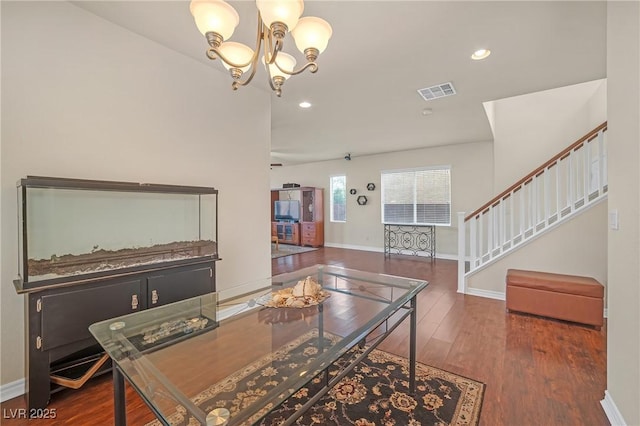 dining area with visible vents, a notable chandelier, wood finished floors, stairway, and baseboards