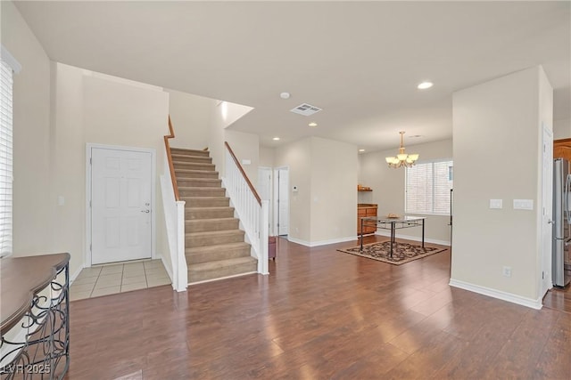 interior space featuring wood finished floors, visible vents, recessed lighting, stairs, and a notable chandelier