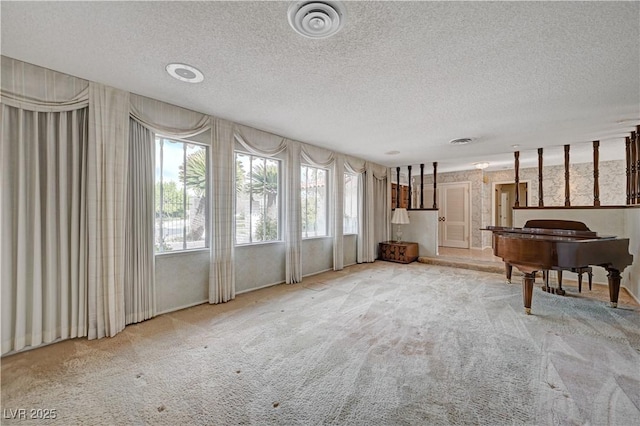 interior space with a textured ceiling, carpet flooring, visible vents, and wallpapered walls