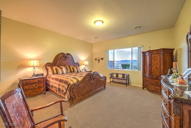 bedroom featuring light colored carpet, visible vents, a textured ceiling, and baseboards