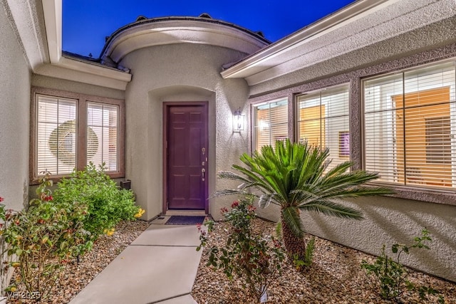 entrance to property with stucco siding