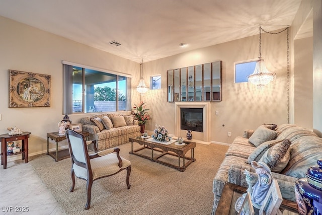 living room with baseboards, visible vents, and a chandelier