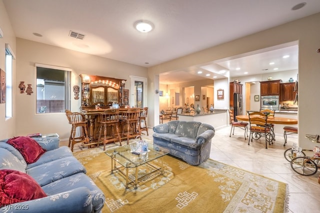 living area featuring a dry bar, light tile patterned floors, baseboards, visible vents, and recessed lighting