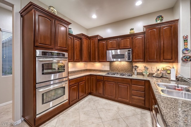 kitchen with light tile patterned floors, recessed lighting, stainless steel appliances, a sink, and light stone countertops