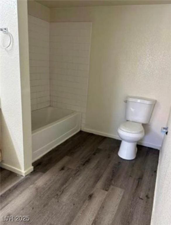 full bathroom with wood finished floors, toilet, and baseboards