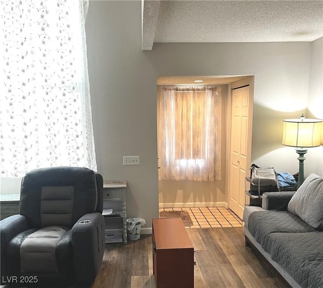 interior space featuring a textured ceiling, baseboards, and wood finished floors