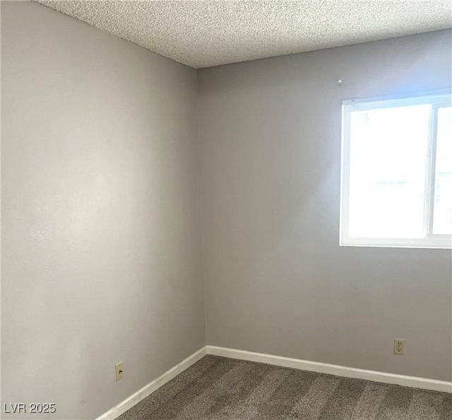 unfurnished room with baseboards, dark colored carpet, and a textured ceiling