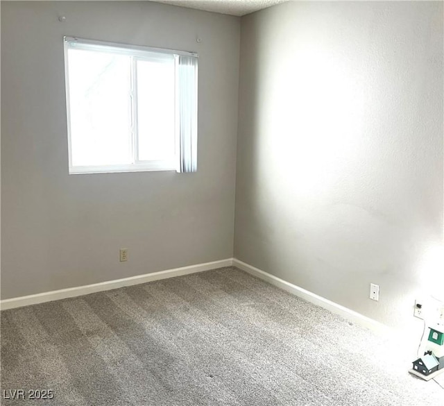 spare room with carpet and baseboards