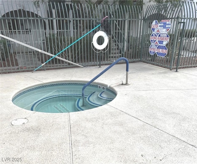 view of pool featuring fence and a hot tub