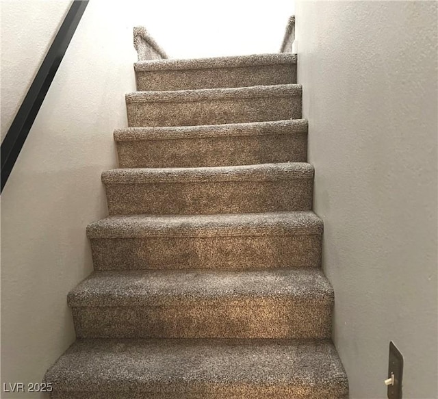 staircase featuring a textured wall