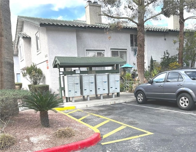 view of property's community featuring mail area and uncovered parking