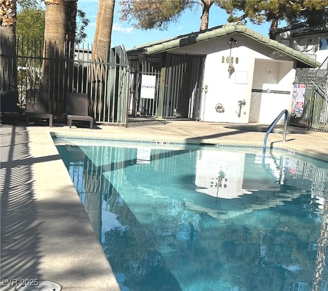 community pool with fence and a patio