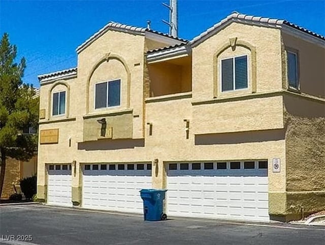 view of building exterior featuring driveway and an attached garage