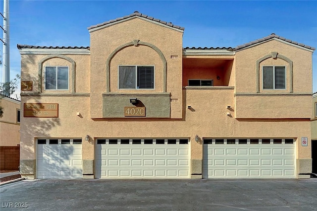 view of front of home featuring a garage, driveway, and stucco siding