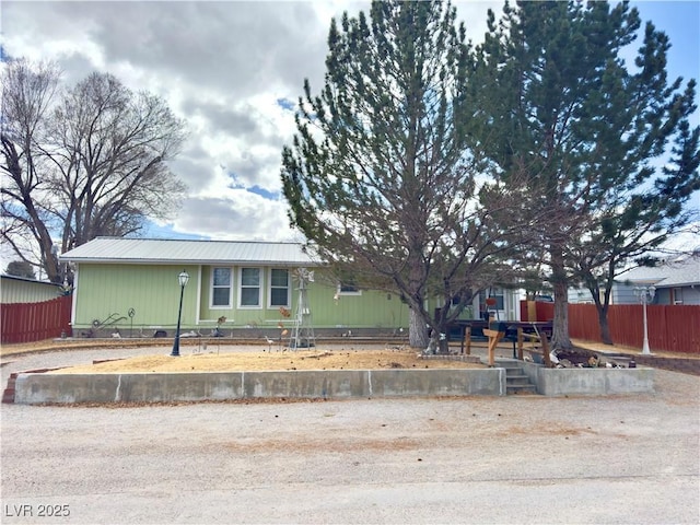 view of front of home with fence and metal roof