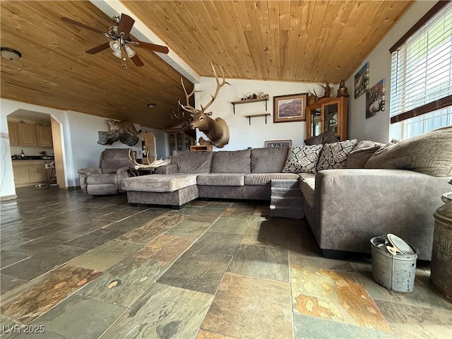 unfurnished living room featuring lofted ceiling, stone tile floors, wooden ceiling, and a ceiling fan