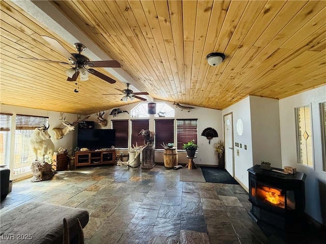 interior space featuring vaulted ceiling, a wood stove, wood ceiling, and stone tile flooring