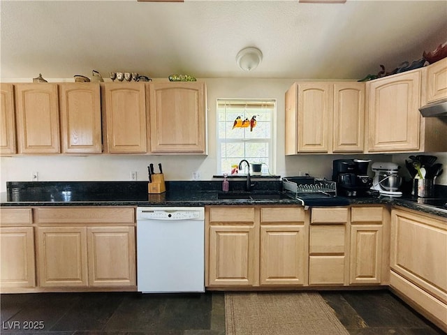 kitchen featuring a sink, dark stone countertops, white dishwasher, and light brown cabinetry