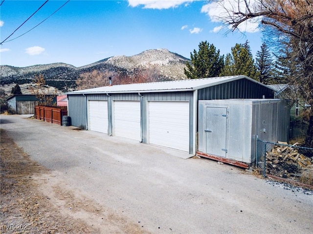 garage featuring a mountain view and fence