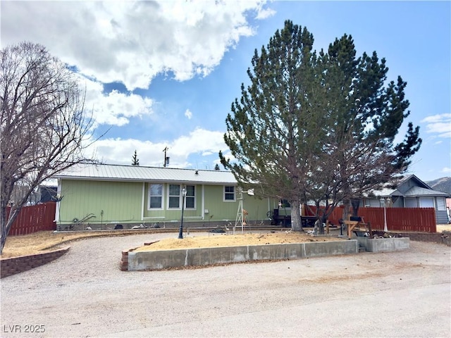 view of front of home featuring a fenced front yard and metal roof