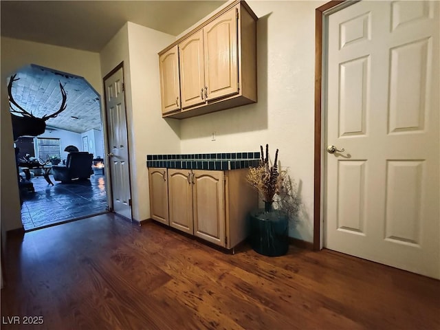 kitchen with light brown cabinets, dark countertops, and dark wood-type flooring