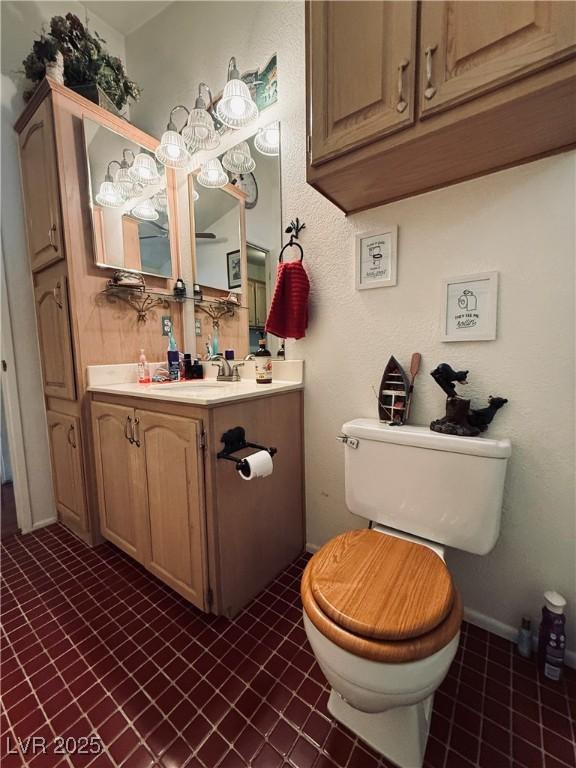 bathroom featuring baseboards, toilet, and vanity