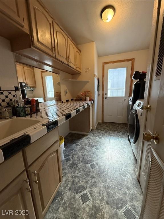 clothes washing area featuring separate washer and dryer and laundry area