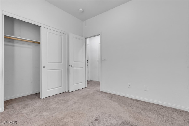 unfurnished bedroom featuring carpet flooring, baseboards, and a closet