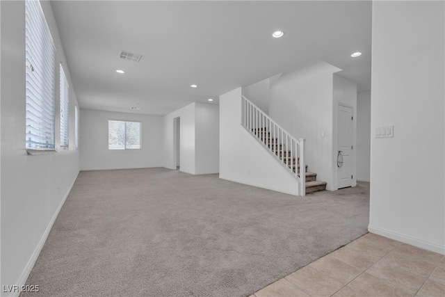 unfurnished living room with light carpet, visible vents, recessed lighting, and stairs