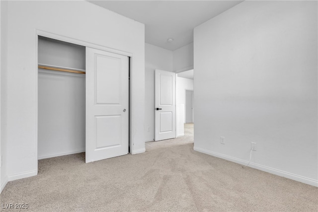 unfurnished bedroom with a closet, carpet floors, and baseboards