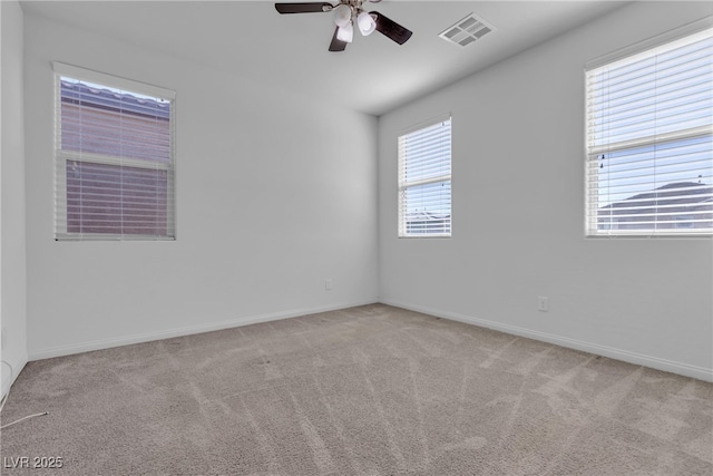 carpeted empty room featuring visible vents, baseboards, and ceiling fan